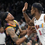 Phoenix Suns guard Damion Lee, left, is fouled by Miami Heat forward Jimmy Butler (22) during the second half of an NBA basketball game in Phoenix, Friday, Jan. 6, 2023. The Heat won 104-96. (AP Photo/Ross D. Franklin)