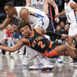 New York Knicks guard Miles McBride (2) fights for a loose ball against Brooklyn Nets center Nic Claxton during the first half of an NBA basketball game, Saturday, Jan. 28, 2023, in New York. (AP Photo/Mary Altaffer)