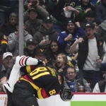 Vancouver Canucks' Dakota Joshua (81) loses his helmet as he and Chicago Blackhawks' Max Domi fight during the second period of an NHL hockey game Tuesday, Jan. 24, 2023, in Vancouver, British Columbia. (Darryl Dyck/The Canadian Press via AP)