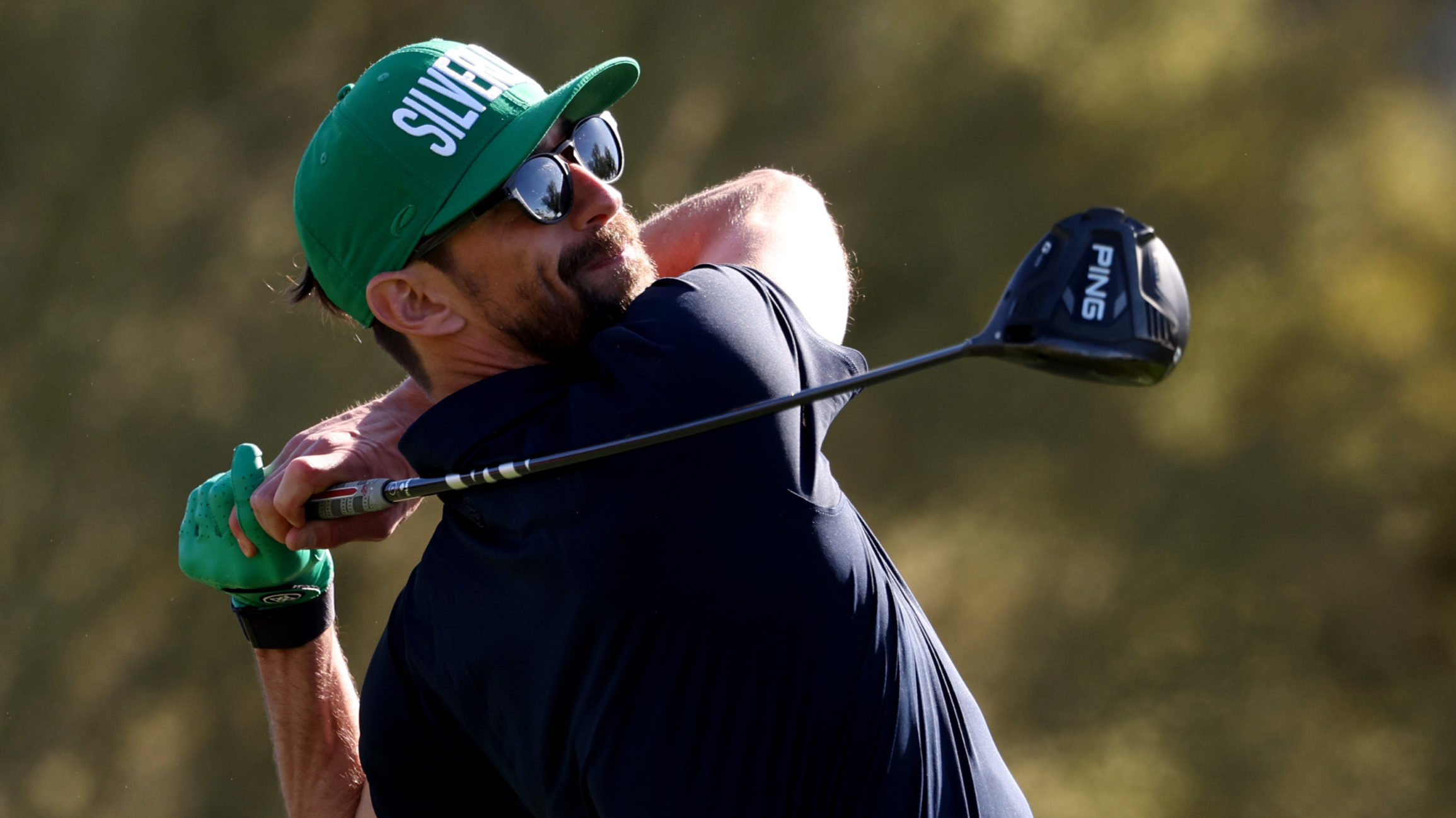 Former Olympic Swimmer Michael Phelps of the United States plays a shot off of the fifth tee during...