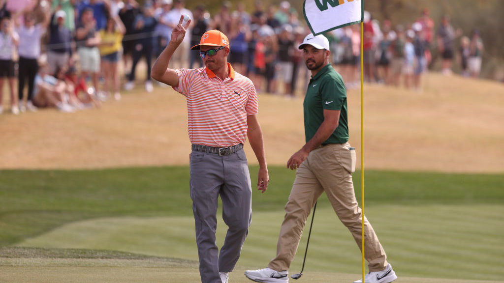 Rickie Fowler of the United States celebrates a hole-in-one on the seventh hole as Jason Day of Aus...