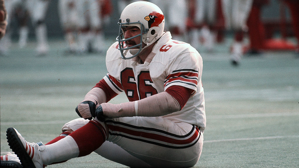 Conrad Dobler #66 of the St. Louis Cardinals sits on the turf and looks on against the Dallas Cowbo...