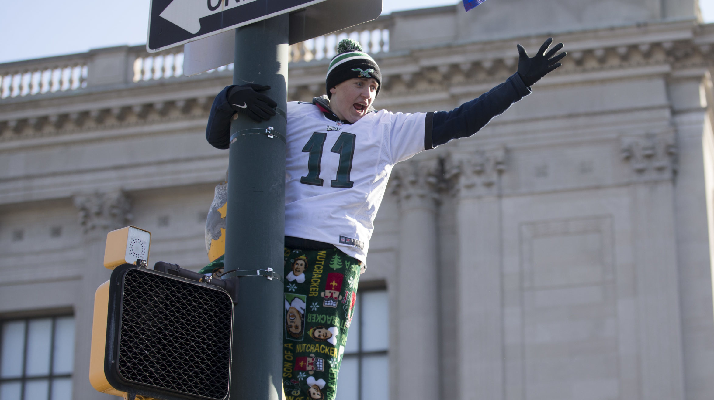 A fan climbs a light pole during the Super Bowl LII parade on February 8, 2018 in Philadelphia, Pen...