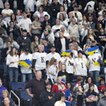 
              Spectators dressed in white cheer for the Ukraine peewee team cheer during a hockey game against the Boston Junior Bruins, Saturday, Feb. 11, 2023 in Quebec City. (Jacques Boissinot/The Canadian Press via AP)
            