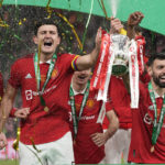 
              Manchester United's Bruno Fernandes, centre right, and Harry Maguire, second from left, hold the trophy during celebration as they won the English League Cup final soccer match between Manchester United and Newcastle United at Wembley Stadium in London, Sunday, Feb. 26, 2023. (AP Photo/Alastair Grant)
            