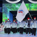 FILE -  Olga Fatkulina and Vadim Shipachyov, of the Russian Olympic Committee, carry a flag into the stadium during the opening ceremony of the 2022 Winter Olympics, on Feb. 4, 2022, in Beijing. Russian athletes were competing under the acronym ROC, for Russian Olympic Committee, for the third time. One year after the invasion of Ukraine began, Russia's reintegration into the world of sports threatens to create the biggest rift in the Olympic movement since the Cold War. (AP Photo/Jae C. Hong, File)