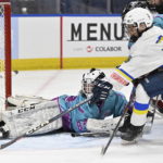 
              Ukraine hockey player Zahar Kovalenko, foreground right, tries to get to the puck as Vermont Flames Academy goalie Kaleb Sanderson covers the net during a game at the International Peewee Tournament in Quebec City, Friday, Feb. 17, 2023.  (Jacques Boissinot/The Canadian Press via AP)
            
