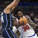 New York Knicks' Julius Randle (30) makes a move to the basket against Orlando Magic's Wendell Carter Jr., left, during the first half of an NBA basketball game Tuesday, Feb. 7, 2023, in Orlando, Fla. (AP Photo/John Raoux)