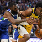 Dallas Mavericks forward Tim Hardaway Jr. reaches for the ball against Indiana Pacers forward Aaron Nesmith during the first half of NBA basketball game in Dallas, Tuesday, Feb. 28, 2023. (AP Photo/Sam Hodde)
