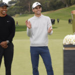 
              FILE - Joaquin Niemann, of Chile, right, stands next to Tiger Woods on the 18th green after winning the Genesis Invitational golf tournament at Riviera Country Club, on Feb. 20, 2022, in the Pacific Palisades area of Los Angeles. Woods is player at the Genesis Invitational this year, but he also is the tournament host who hands out the trophy. (AP Photo/Ryan Kang)
            