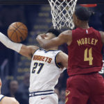 Cleveland Cavaliers forward Evan Mobley (4) defends a shot against Denver Nuggets guard Jamal Murray (27) during the first half of an NBA basketball game, Thursday, Feb. 23, 2023, in Cleveland. (AP Photo/Ron Schwane)