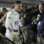 Alex Bowman smiles after climbing out of his car after taking pole position during qualifying for the NASCAR Daytona 500 auto race Wednesday, Feb. 15, 2023, at Daytona International Speedway in Daytona Beach, Fla. (AP Photo/Chris O'Meara)