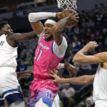 
              Washington Wizards center Daniel Gafford (21) looks to pass while defended by Minnesota Timberwolves guard Anthony Edwards (1), left, and center Rudy Gobert (27) during the first half of an NBA basketball game, Thursday, Feb. 16, 2023, in Minneapolis. (AP Photo/Abbie Parr)
            