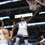 Minnesota Timberwolves guard Anthony Edwards (1) goes up for a shot in front of Dallas Mavericks' Christian Wood, right, as Kyle Anderson (5) looks on in the first half of an NBA basketball game, Monday, Feb. 13, 2023, in Dallas. (AP Photo/Tony Gutierrez)