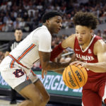 Alabama guard Mark Sears is fouled by Auburn guard K.D. Johnson as he breaks for the basket during the first half of an NCAA college basketball game, Saturday, Feb. 11, 2023, in Auburn, Ala. (AP Photo/Butch Dill)