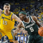 
              Michigan State guard Tre Holloman (5) is defended by Michigan guard Joey Baker (15) during the first half of an NCAA college basketball game, Saturday, Feb. 18, 2023, in Ann Arbor, Mich. (AP Photo/Carlos Osorio)
            