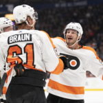 Philadelphia Flyers' Justin Braun, foreground, is congratulated by Joel Farabee, right, after scoring a goal against the Vancouver Canucks during the first period of an NHL hockey game Saturday, Feb. 18, 2023, in Vancouver, British Columbia. (Rich Lam/The Canadian Press via AP)