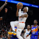 
              Los Angeles Clippers' Terance Mann (14) drives to the basket between Phoenix Suns' Torrey Craig, left, and Deandre Ayton during the first half of an NBA basketball game Thursday, Feb. 16, 2023, in Phoenix. (AP Photo/Darryl Webb)
            