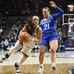 UConn's Nika Muhl drives to the basket as Creighton's Molly Mogensen (21) defends during the first half of an NCAA college basketball game Wednesday, Feb. 15, 2023, in Storrs, Conn. (AP Photo/Jessica Hill)