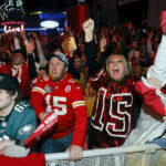 A Philadelphia Eagles fan, left, reacts as Kansas City fans celebrate a Chiefs touchdown during the NFL Super Bowl 57 football game at a watch party in the Power and Light entertainment district in Kansas City, Mo., Sunday, Feb. 12, 2023. (AP Photo/Colin E. Braley)