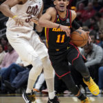 
              Atlanta Hawks guard Trae Young (11) drives past Cleveland Cavaliers center Jarrett Allen, left, during the first half of an NBA basketball game Friday, Feb. 24, 2023, in Atlanta. (AP Photo/John Bazemore)
            