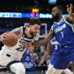 Minnesota Timberwolves guard Austin Rivers (25) drives to the basket as Dallas Mavericks' Theo Pinson (1) defends in the first half of an NBA basketball game, Monday, Feb. 13, 2023, in Dallas. (AP Photo/Tony Gutierrez)