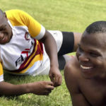 
              In this undated photo provided by Lindsay Myeni, is Lindani Myeni, foreground with no shirt on, resting on the grass after a rugby match in Eshowe, South Africa. Myeni was fatally shot by Honolulu police in 2021 after he physically attacked officers, who responded when an upset occupant of a home complained a stranger had entered uninvited wearing a feathered headband and made bizarre comments. Results of studies of Myeni's brain tissue, obtained by The Associated Press, show the 29-year-old South African rugby player had Stage 3 CTE, or brain trauma caused by repeated concussions. (Lindsay Myeni via AP)
            