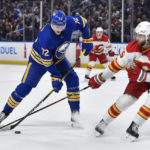 
              Buffalo Sabres center Tage Thompson, left, looks to shoot as Calgary Flames defenseman Noah Hanifin defends during the second period of an NHL hockey game in Buffalo, N.Y., Saturday, Feb. 11, 2023. (AP Photo/Adrian Kraus)
            