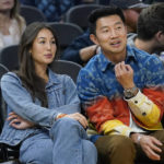 
              FILE - Actor Simu Liu, right, watches an NBA basketball game between the Golden State Warriors and the Miami Heat in San Francisco, Oct. 27, 2022. Marvel Shang-Chi actor Liu wants everyone who attends an event at Chase Center to feel welcome, comfortable and supported, just as he has been in the five months since opening up about his own challenges with anxiety. (AP Photo/Jeff Chiu, File)
            