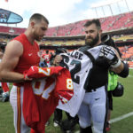 FILE - Kansas City Chiefs tight end Travis Kelce, left, and his brother, Philadelphia Eagles center Jason Kelce (62) prepare to exchange jerseys following an NFL football game in Kansas City, Mo., on Sept. 17, 2017.  For the first time in Super Bowl history, a pair of siblings will square off on the NFL's grandest stage. (AP Photo/Ed Zurga, File)