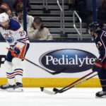 
              Edmonton Oilers forward Leon Draisaitl, left, passes the puck in front of Columbus Blue Jackets forward Johnny Gaudreau during the second period of an NHL hockey game in Columbus, Ohio, Saturday, Feb. 25, 2023. (AP Photo/Paul Vernon)
            