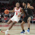
              Houston guard Marcus Sasser (0) drives the lane against Memphis guard Elijah McCadden, right, during the second half of an NCAA college basketball game, Sunday, Feb. 19, 2023, in Houston. (AP Photo/Kevin M. Cox)
            