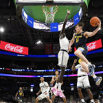 
              Marquette guard Tyler Kolek (11) goes to the basket against Georgetown forward Akok Akok, center, during the second half of an NCAA college basketball game, Saturday, Feb. 11, 2023, in Washington. Marquette won 89-75. (AP Photo/Nick Wass)
            