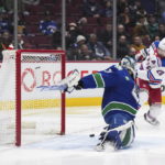 New York Rangers' Chris Kreider, right, scores against Vancouver Canucks goalie Arturs Silovs during the second period of an NHL hockey game Wednesday, Feb. 15, 2023, in Vancouver, British Columbia. (Darryl Dyck/The Canadian Press via AP)