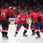 Washington Capitals defenseman Erik Gustafsson, center, and teammates celebrate a goal by right wing T.J. Oshie, right, during the first period of an NHL hockey game against the New York Rangers, Saturday, Feb. 25, 2023, in Washington. (AP Photo/Julio Cortez)