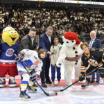 Ukraine peewee team captain Mykyta Staskevich, left, and Boston Junior Bruins captain Brendan O'Toole pose for the official face off dropped by tournament mascot Bonhomme Carnaval before playing a hockey game, Saturday, Feb, 11, 2023, in Quebec City. (Jacques Boissinot/The Canadian Press via AP)