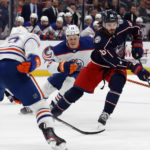 
              Columbus Blue Jackets forward Kirill Marchenko, right, controls the puck in front of Edmonton Oilers defenseman Tyson Barrie, left, and forward Jesse Puljujarvi during the second period of an NHL hockey game in Columbus, Ohio, Saturday, Feb. 25, 2023. (AP Photo/Paul Vernon)
            