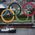 
              FILE - Boats prepare to tow giant Olympic rings as they are removed from the waterfront area at Odaiba Marine Park after 2020 Summer Olympics came to an end on Aug. 8 in Tokyo, Japan, Aug. 11, 2021. The Tokyo Olympic bid-rigging scandal widened Tuesday, Feb. 28, 2023, with Japanese advertising giant Dentsu and five other companies being charged by Tokyo district prosecutors. (Kim Kyung-Hoon/Pool Photo via AP, File)
            