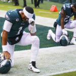 
              FILE - Philadelphia Eagles quarterbacks Jalen Hurts (1) kneels with running back Miles Sanders (26) during the NFL football game against the Jacksonville Jaguars, Sunday, Oct. 2, 2022, in Philadelphia. Public display of faith is nothing new in football or sports.(AP Photo/Chris Szagola, File)
            