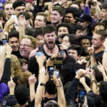 Northwestern center Matthew Nicholson, center, celebrates with fans after Northwestern defeated Purdue 64-58 in an NCAA college basketball game in Evanston, Ill., Sunday, Feb. 12, 2023. (AP Photo/Nam Y. Huh)