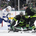 Dallas Stars goaltender Scott Wedgewood (41) and center Radek Faksa (12) attempt to clear the puck under pressure from Tampa Bay Lightning center Brayden Point (21) in the second period of an NHL hockey game, Saturday, Feb. 11, 2023, in Dallas. (AP Photo/Tony Gutierrez)