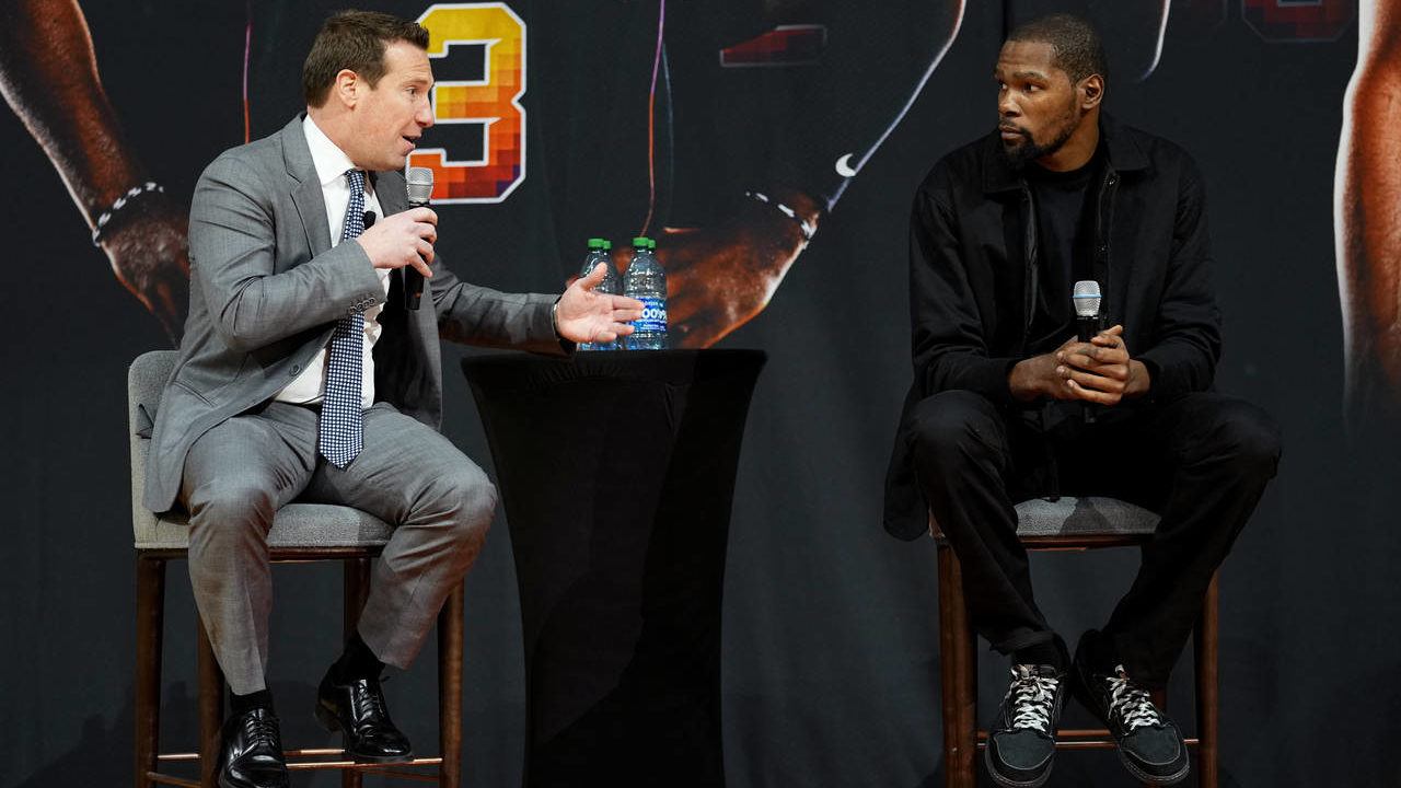 Phoenix Suns forward Kevin Durant listens as owner Mat Ishbia, left, speaks during an NBA basketbal...