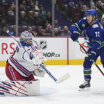 New York Rangers goalie Igor Shesterkin, left, makes a blocker save as Vancouver Canucks' Anthony Beauvillier (72) watches during the third period of an NHL hockey game Wednesday, Feb. 15, 2023, in Vancouver, British Columbia. (Darryl Dyck/The Canadian Press via AP
