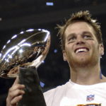 FILE - In this Feb. 1, 2004, file photo, New England Patriots quarterback Tom Brady holds the Vince Lombardi Trophy after the Patriots beat the Carolina Panthers 32-29 in Super Bowl 38 in Houston. Brady, who won a record seven Super Bowls for New England and Tampa, has announced his retirement, Wednesday, Feb. 1, 2023.  (AP Photo/Dave Martin, File)