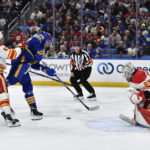 
              Buffalo Sabres left wing Zemgus Girgensons, center, is tied up with Calgary Flames defenseman MacKenzie Weegar, left, while trying to get a shot off on goalie Jacob Markstrom during the second period of an NHL hockey game in Buffalo, N.Y., Saturday, Feb. 11, 2023. (AP Photo/Adrian Kraus)
            