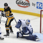 Pittsburgh Penguins left wing Drew O'Connor (10) looks back after he redirected the puck past Tampa Bay Lightning goalie Brian Elliott (1) as Lightning defenseman Victor Hedman (77) applies coverage during the first period of an NHL hockey game, Sunday, Feb. 26, 2023, in Pittsburgh. (AP Photo/Philip G. Pavely)