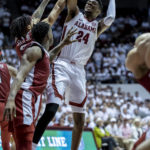 Alabama forward Brandon Miller (24) fires off a shot with Arkansas guard Nick Smith Jr. (3) and guard Davonte Davis (4) defending during the second half of an NCAA college basketball game, Saturday, Feb. 25, 2023, in Tuscaloosa, Ala. (AP Photo/Vasha Hunt)
