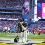 Philadelphia Eagles quarterback Jalen Hurts (1) kneels before the start of the NFL Super Bowl 57 football game between the Kansas City Chiefs and the Philadelphia Eagles, Sunday, Feb. 12, 2023, in Glendale, Ariz. (AP Photo/Abbie Parr)