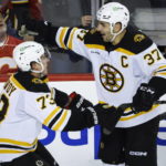Boston Bruins defenceman Charlie McAvoy, left, celebrates his overtime goal against the Calgary Flames with forward Patrice Bergeron during an NHL hockey game Tuesday, Feb. 28, 2023, in Calgary, Alberta. (Jeff McIntosh/The Canadian Press via AP)