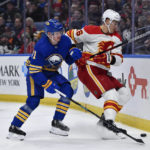 
              Calgary Flames defenseman Nikita Zadorov, right, battles for position over the puck with Buffalo Sabres left wing Victor Olofsson during the second period of an NHL hockey game in Buffalo, N.Y., Saturday, Feb. 11, 2023. (AP Photo/Adrian Kraus)
            